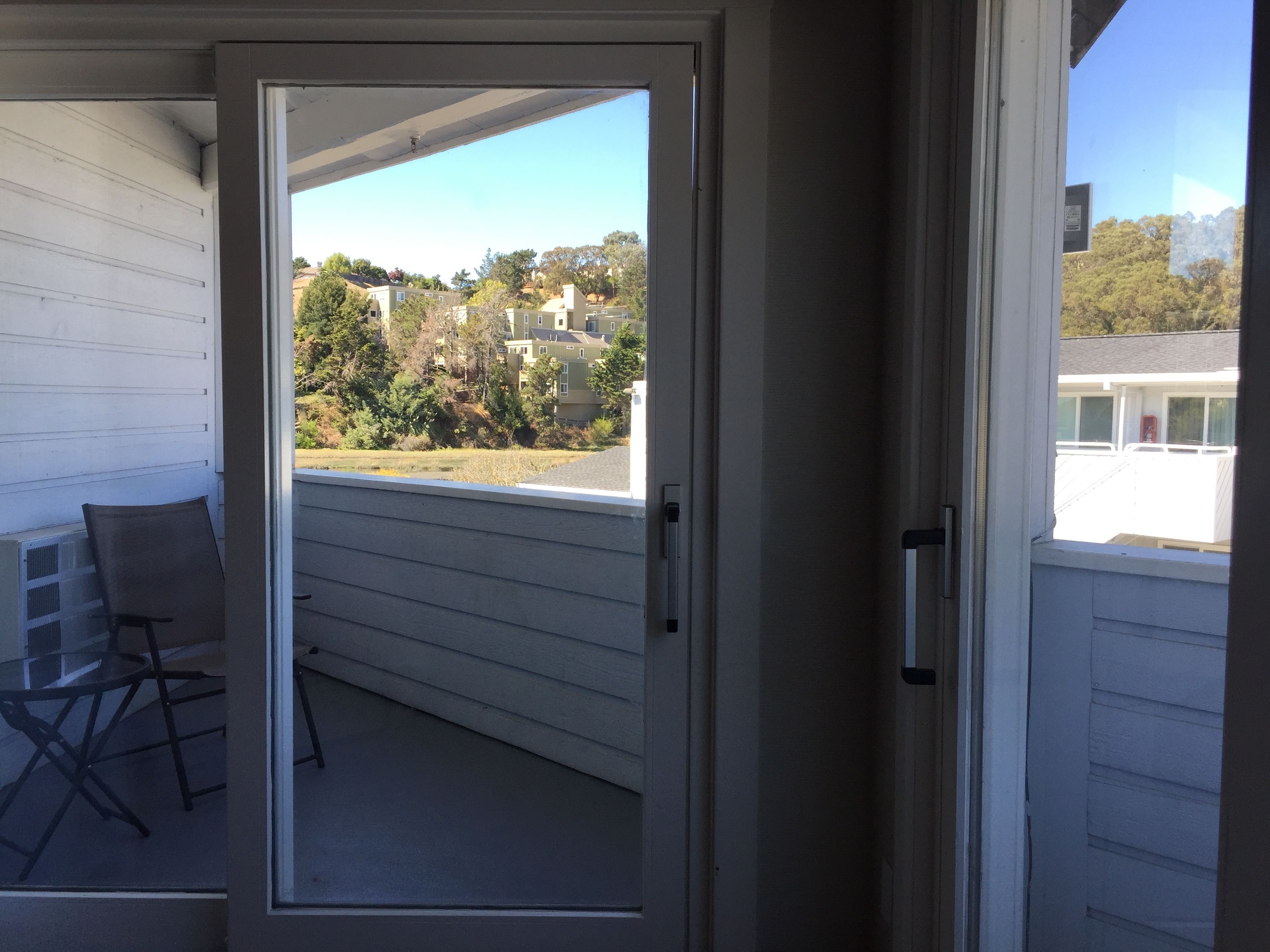 Un balcon donnant sur des immeubles d’habitation et des arbres.