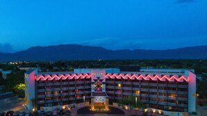 A multi-story hotel with a central atrium, balconies, and a view of distant mountains. - Nativo Lodge Hotel Albuquerque (Albuquerque)
