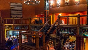 A multi-level interior with wooden railings, a staircase, and various seating areas. - Nativo Lodge Hotel Albuquerque (Albuquerque)
