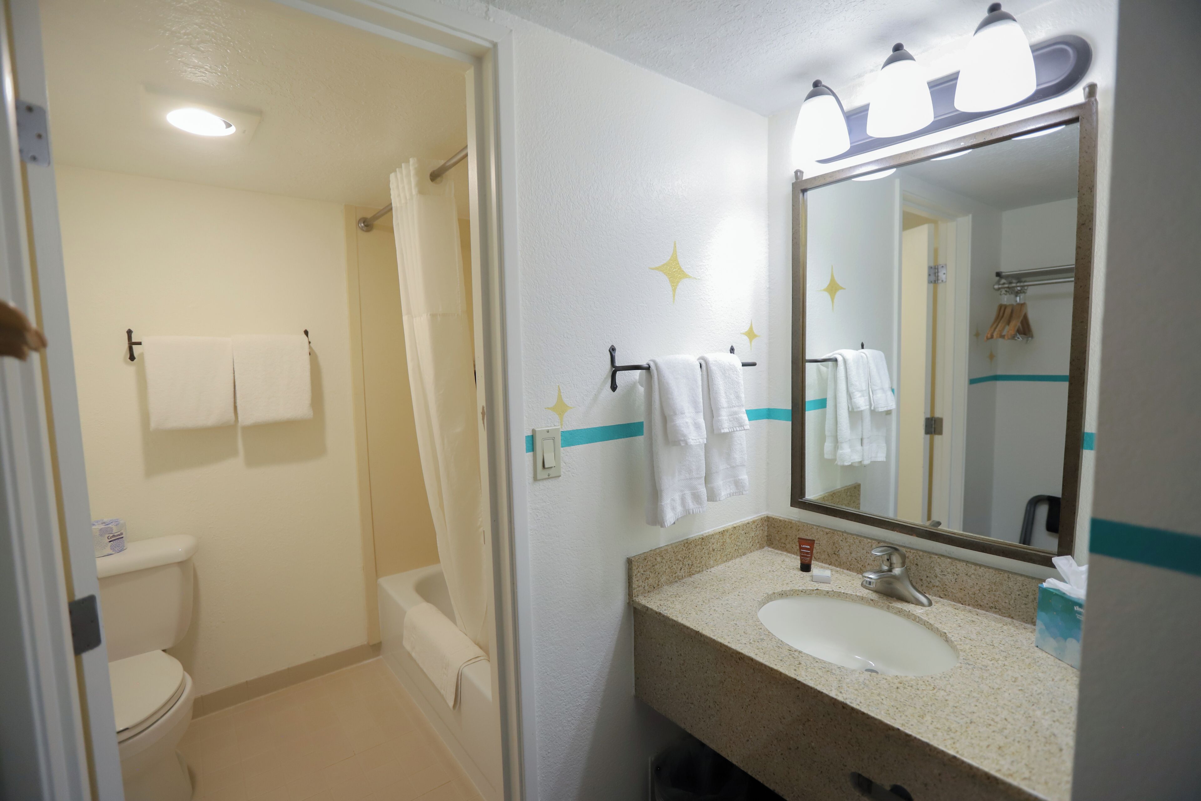 Une salle de bain équipée de toilettes, d’une douche, d’un lavabo et d’un miroir.