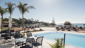 Piscine extérieure, parasols de plage, chaises longues