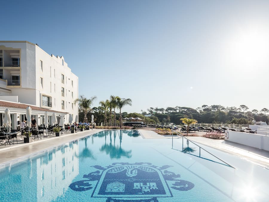 Een buitenzwembad, parasols voor strand/zwembad