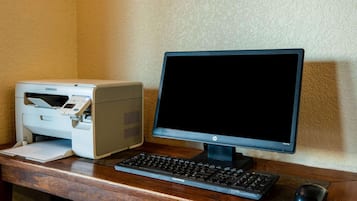 Configuración de computadora de escritorio con una impresora Samsung, un monitor HP, un teclado Compaq y un ratón sobre un escritorio de madera.