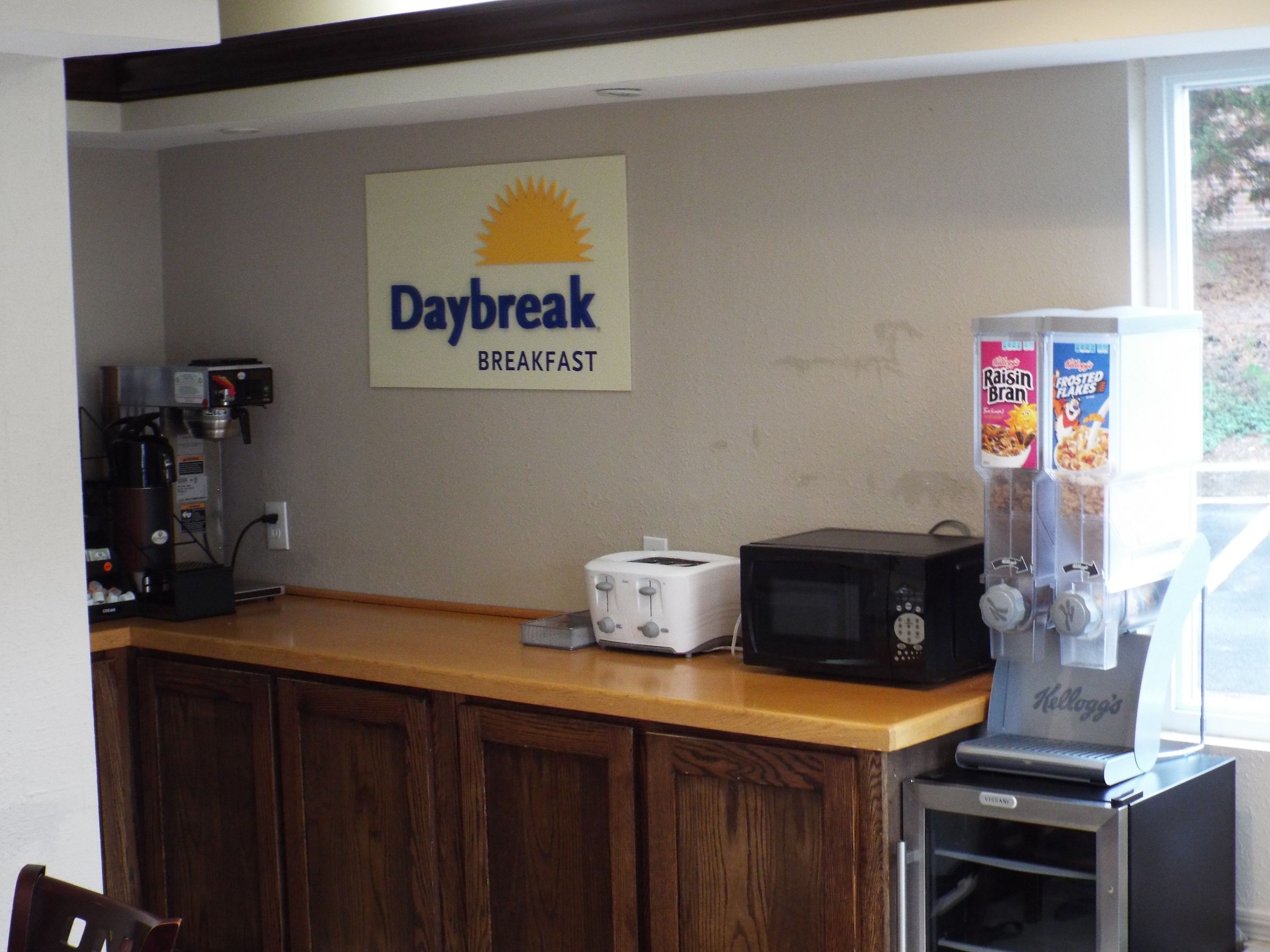 A breakfast area with a coffee machine, toaster, microwave, and cereal dispensers.