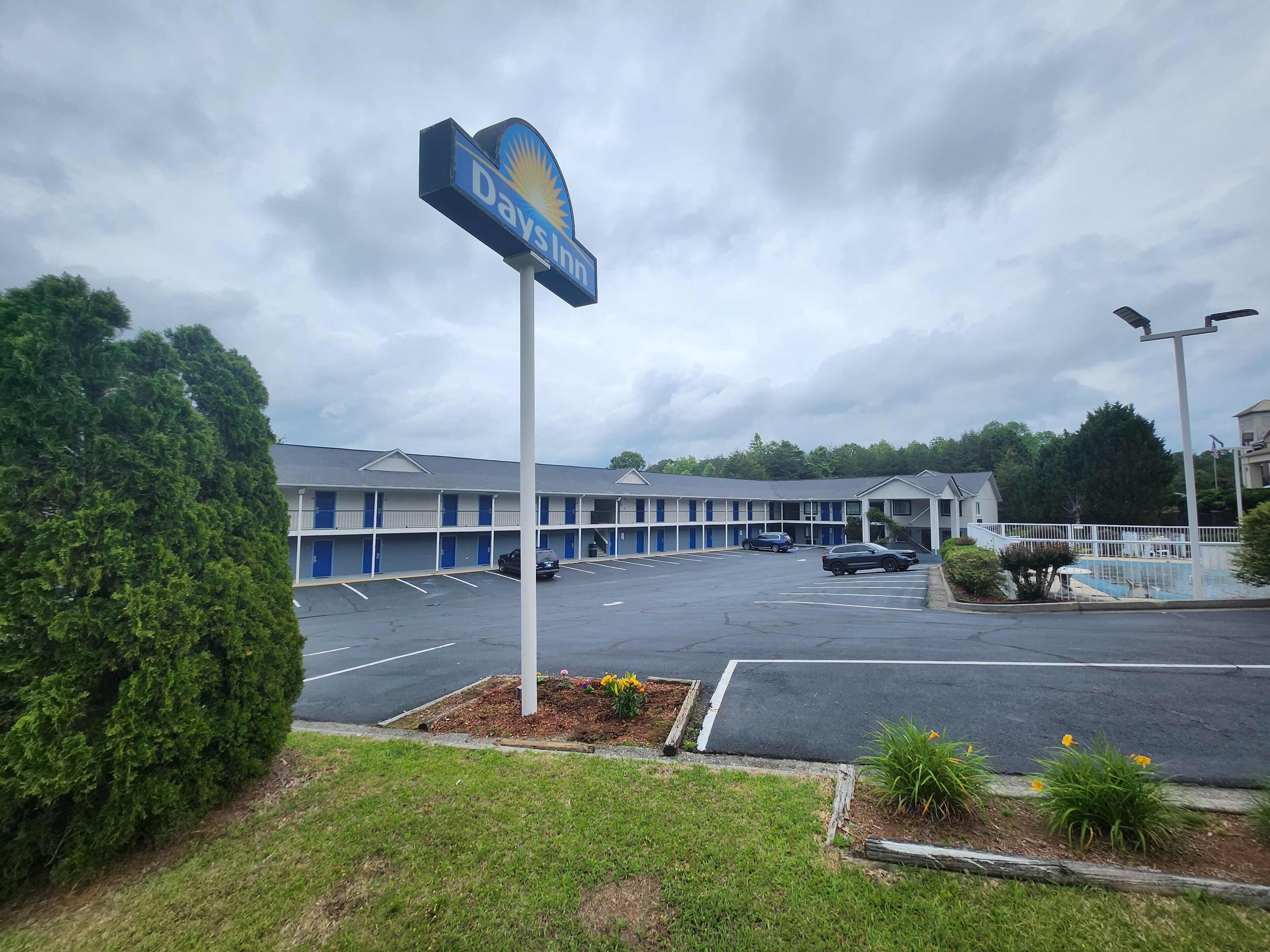A Days Inn with a parking lot and a row of rooms.