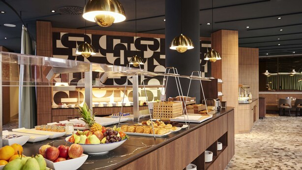 A buffet area with various fruits, pastries, and breakfast items. - NH Frankfurt Airport (Kelsterbach)