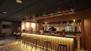 A modern bar area with a bar counter, stools, and shelves with bottles. - NH Frankfurt Airport (Kelsterbach)