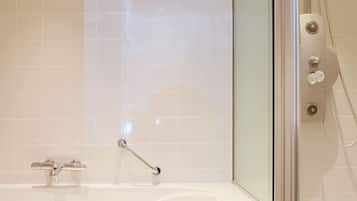 A modern bathroom with a glass-enclosed shower, a white bathtub, and a handheld showerhead.