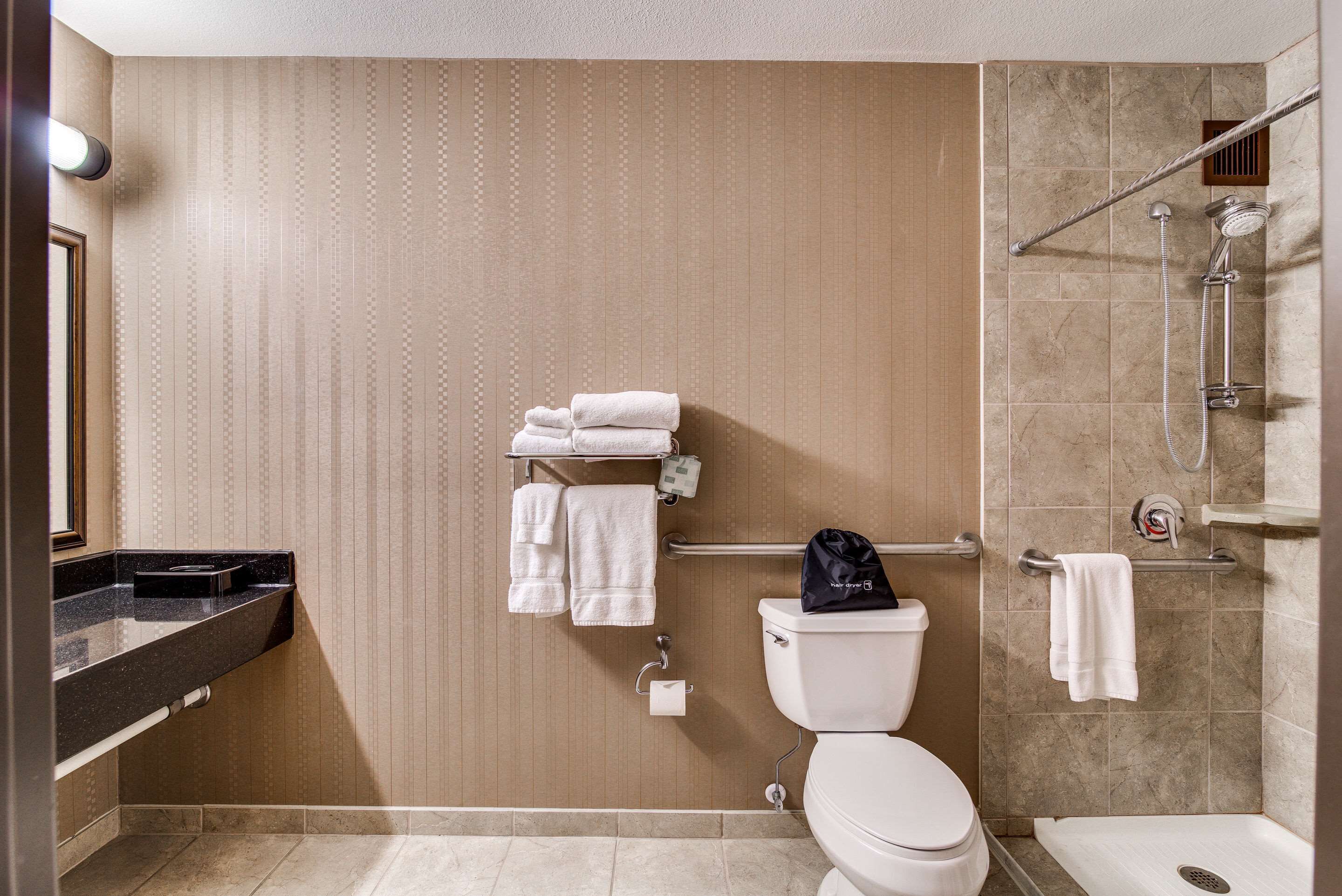 A modern bathroom with a toilet, sink, and shower area.