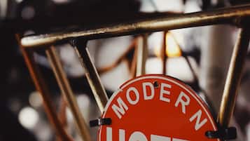 A red sign with the text "MODERN HOTEL" and "BIKE #1" on a metal chair.