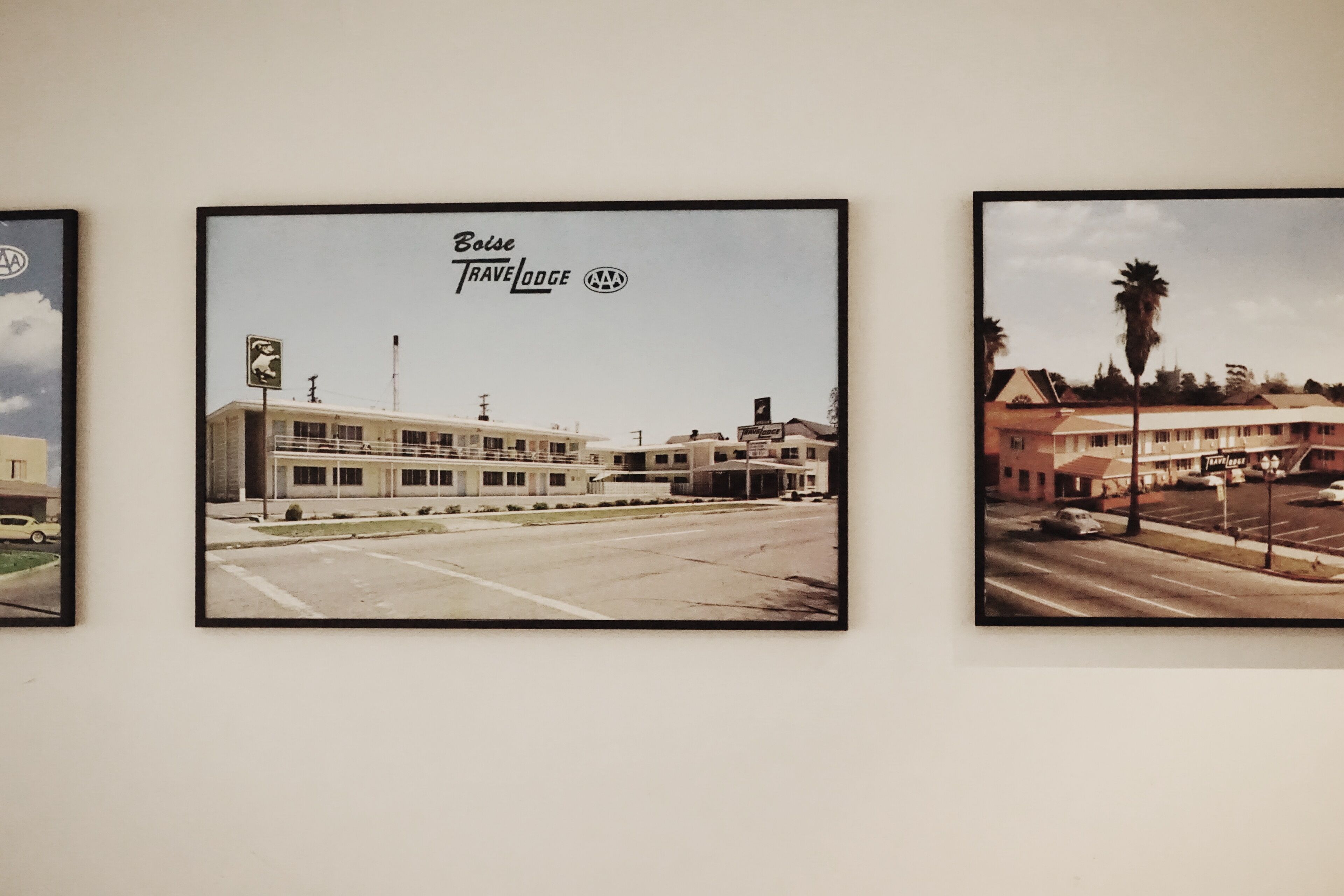 Tres fotografías enmarcadas de edificios con señalización que indica 'Boise Travel Lodge'.