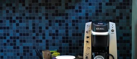 A kitchen area with a microwave, a coffee maker, and a tray with a mug and a container.