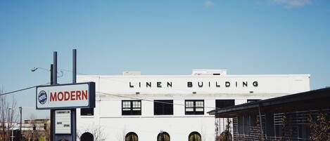 A white building with arched windows and the words "LINEN BUILDING" on the facade.