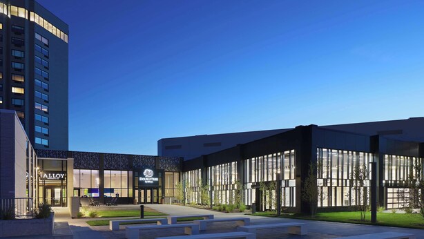 Un hôtel moderne doté d’une cour intérieure, d’un espace extérieur aménagé et d’une entrée bien éclairée.