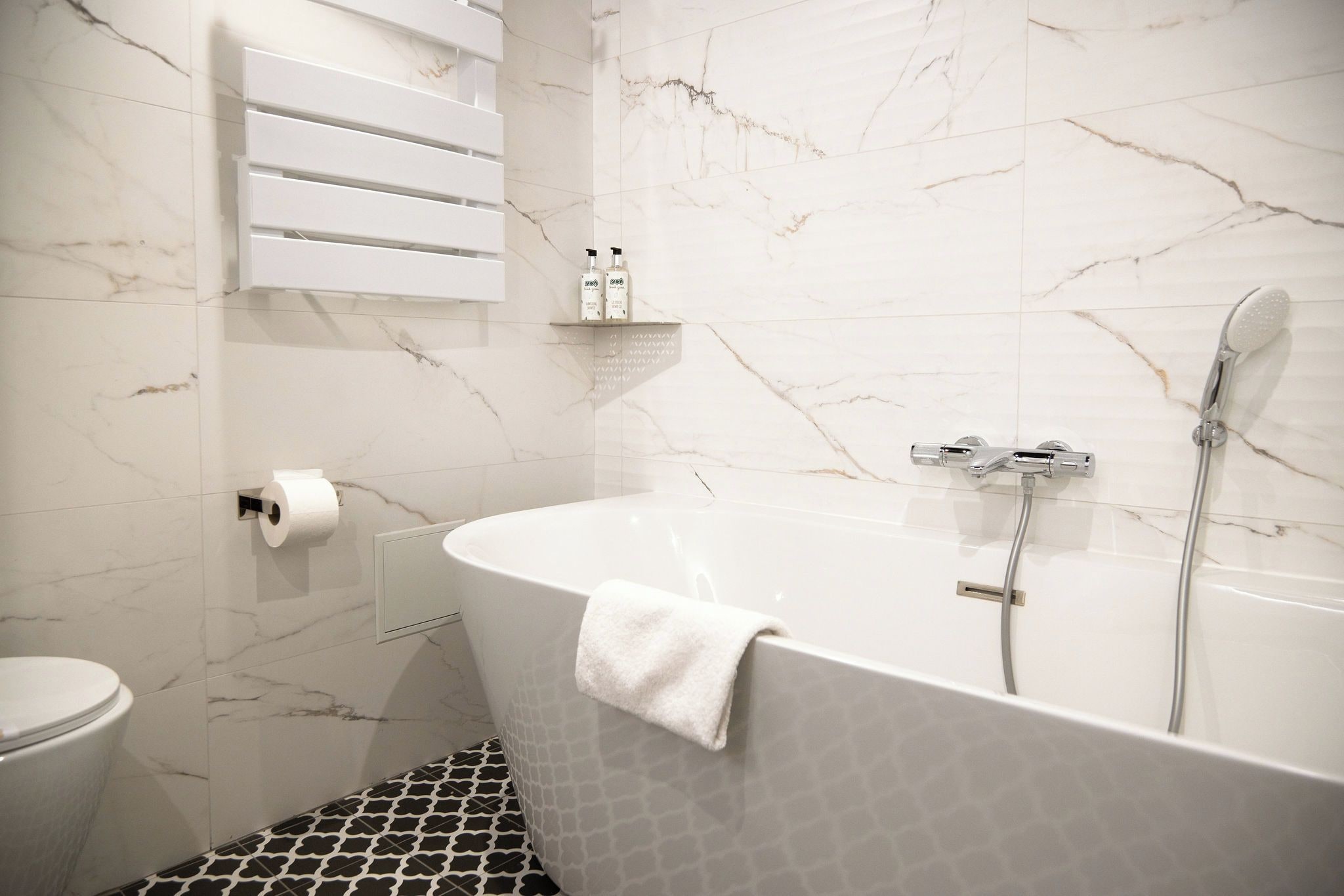 A bathroom with a freestanding bathtub, a toilet, and a shower.