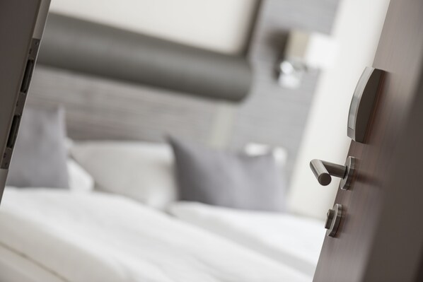 A modern bedroom with a neatly made bed, a bedside table, and a headboard. - Hotel Westfalia (Bremen)