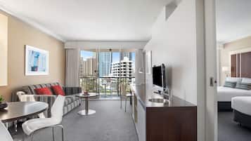 Ein modernes Hotelzimmer mit Balkon, einer Couch, einem Essbereich und einem Bett.
