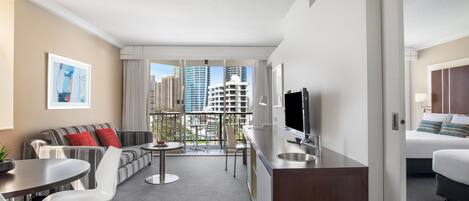 Une chambre d’hôtel moderne dotée d’un balcon, d’un canapé, d’un coin repas et d’un lit.