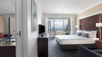 Ein modernes Hotelzimmer mit einem großen Bett, einem Schreibtisch, einem Fernseher und einem Balkon mit Blick auf die Stadt.
