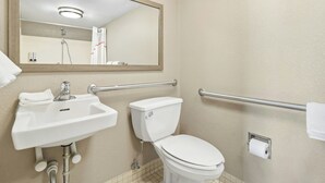Un baño con lavamanos, inodoro y espejo.
