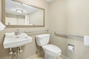 Une salle de bain avec un lavabo, des toilettes et un miroir.