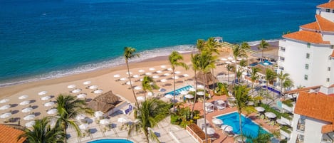 A resort with a pool, beach, and ocean view.