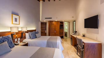 A hotel room with two beds, a desk, a TV, and a wardrobe.