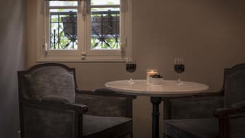 A dining area with two chairs, a round table, and two wine glasses.