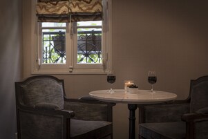 A dining area with two chairs, a round table, and two wine glasses.