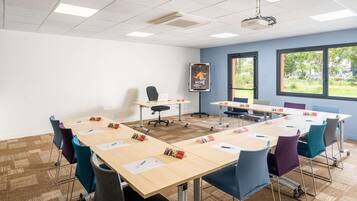 A conference room with a large table, chairs, a projector, and a whiteboard.