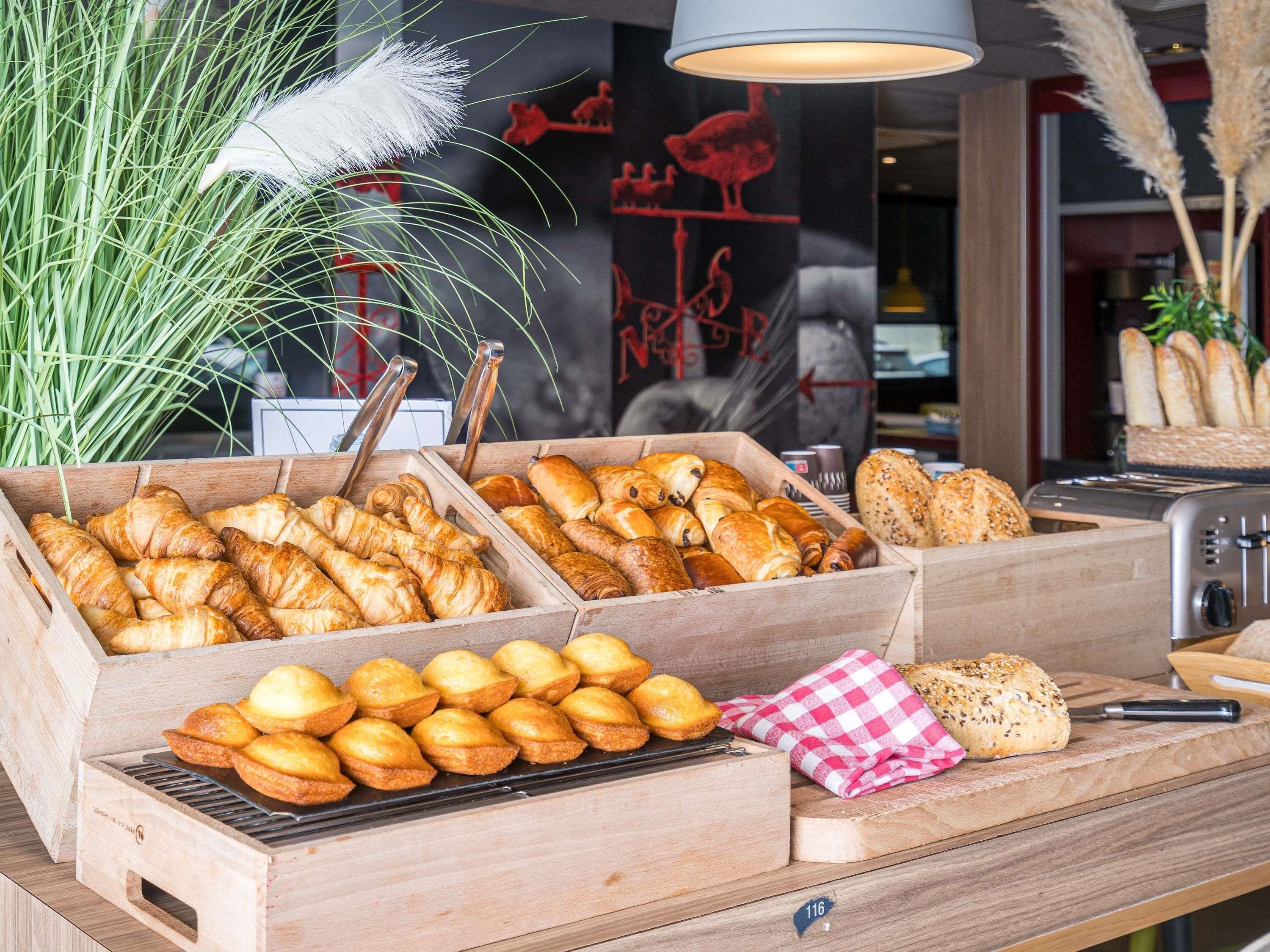Un buffet de petit-déjeuner proposant diverses viennoiseries, un grille-pain et une nappe à carreaux sur le comptoir.