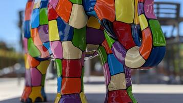 Une sculpture d’éléphant en mosaïque aux couleurs vives, placée sur un socle.