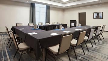 A conference room with a long table, chairs, and a podium.