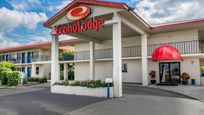 A motel with a prominent red and white sign, a covered entrance, and a balcony on the second floor. - Econo Lodge Sebring (Avon Park)