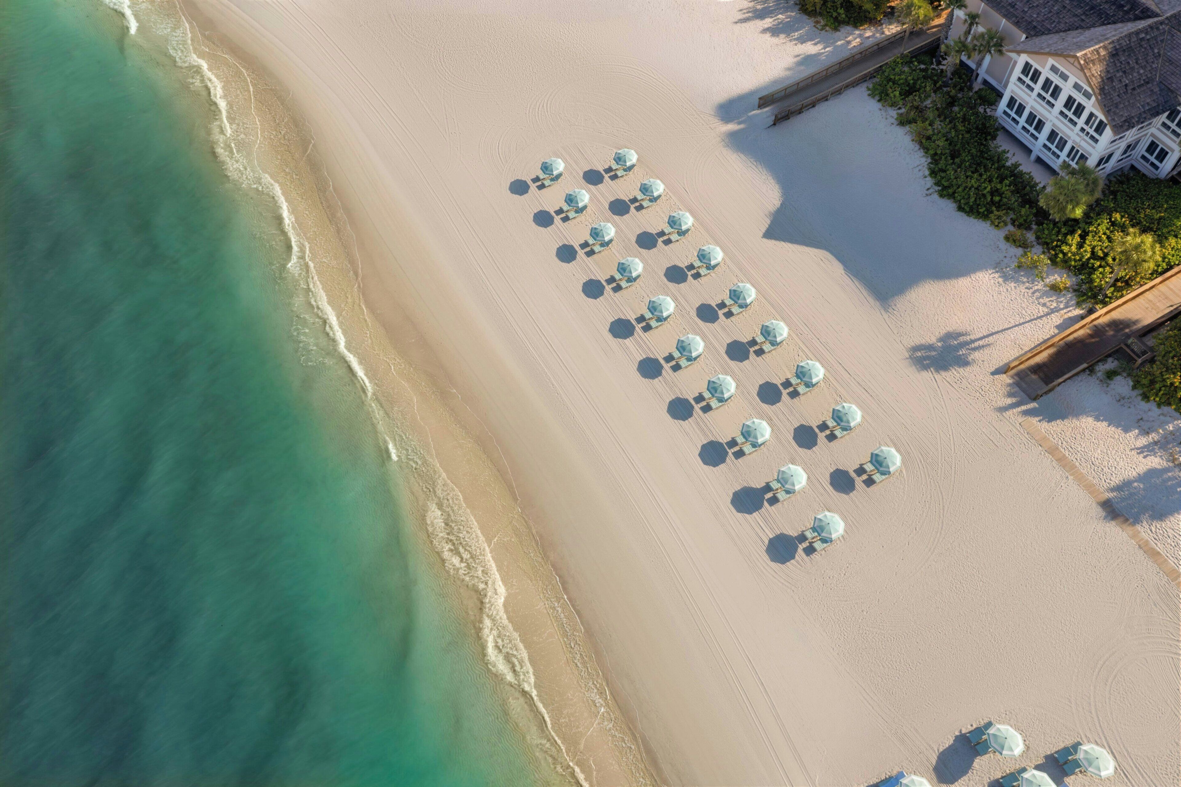 On the beach, white sand, beach cabanas, sun loungers