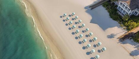 On the beach, white sand, beach cabanas, sun-loungers