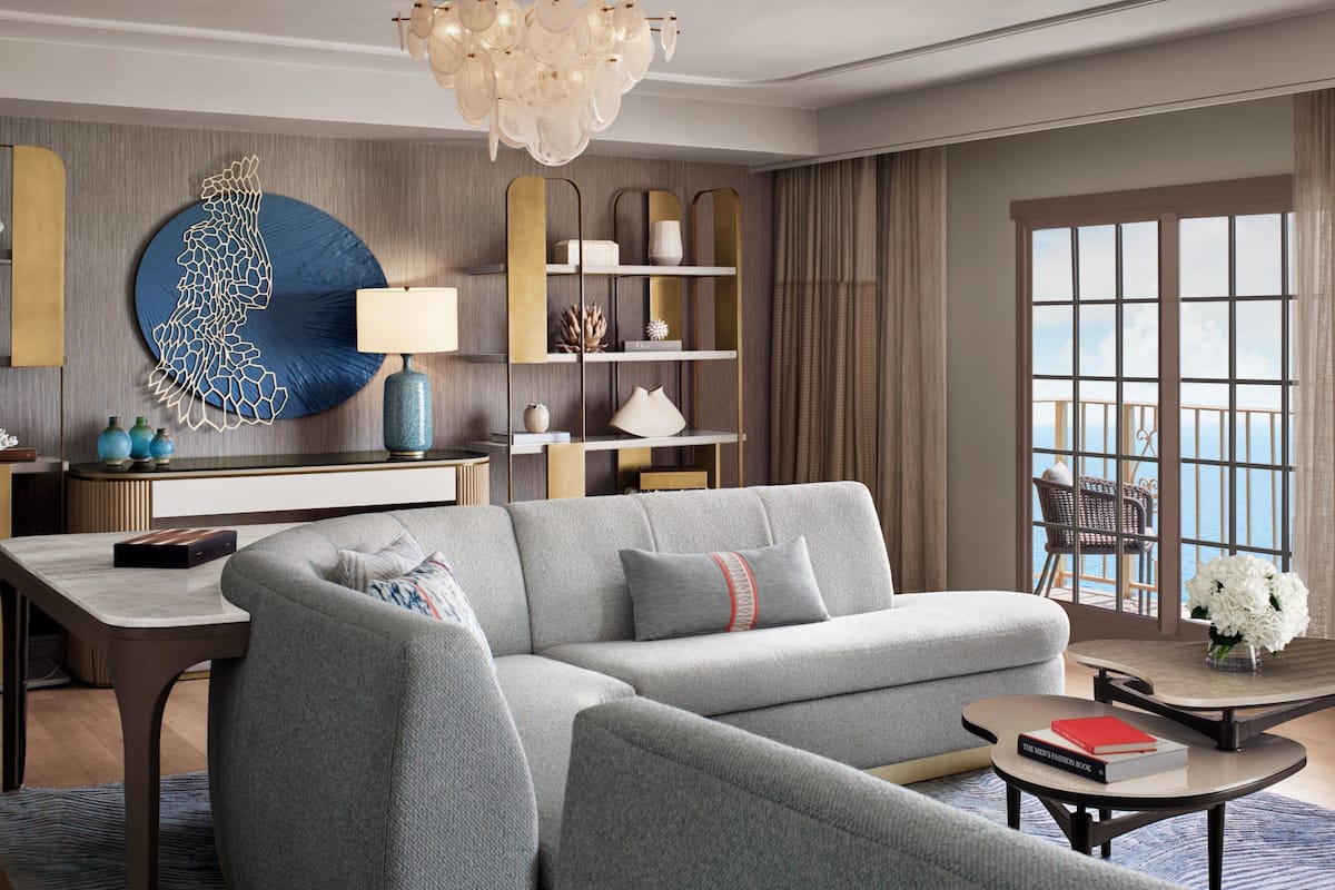 Ein modernes Wohnzimmer mit grauem Sofa, rundem Couchtisch und einer Wanddekoration.
