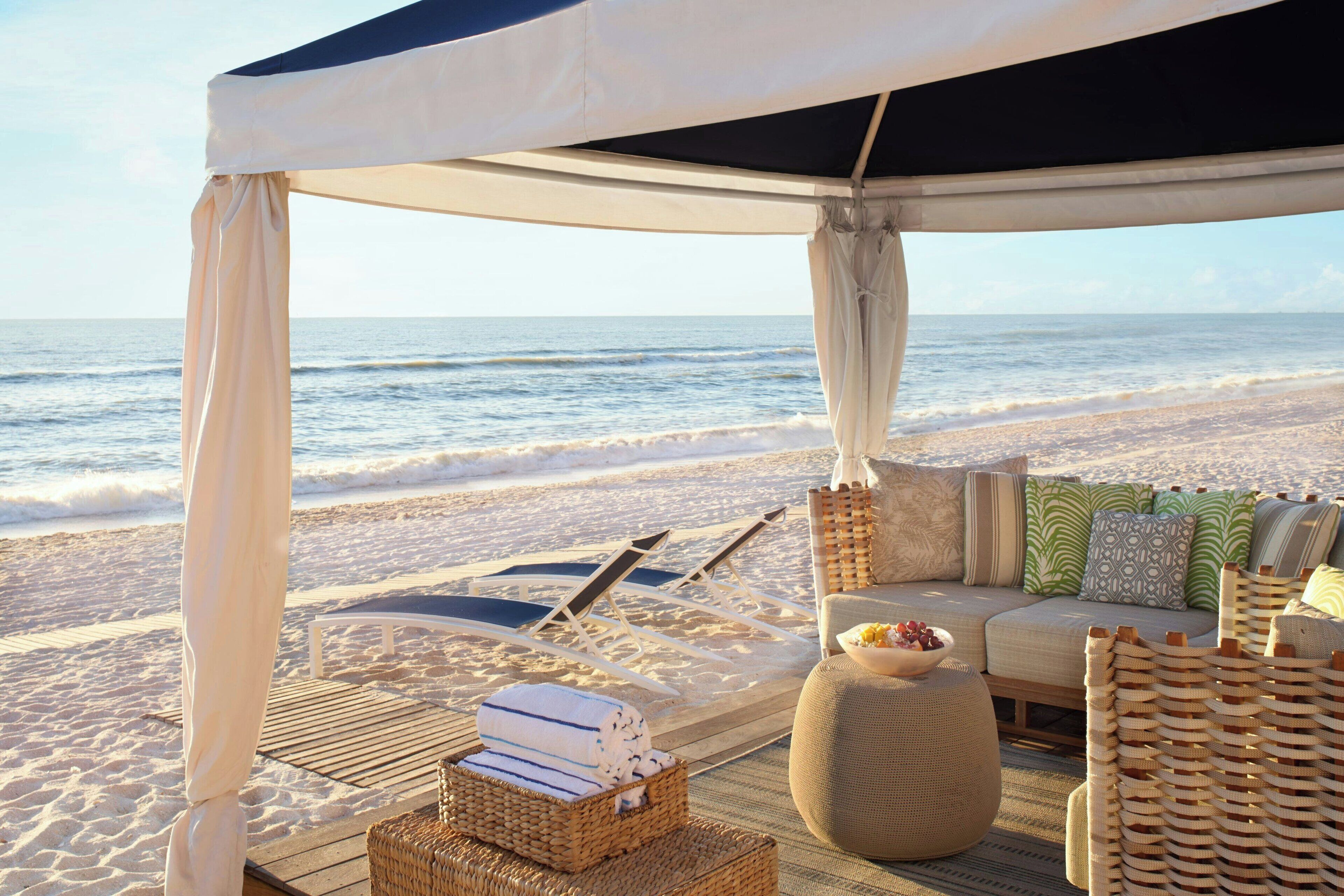 On the beach, white sand, beach cabanas, sun loungers