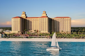 A large hotel with multiple towers and a beach in the background.