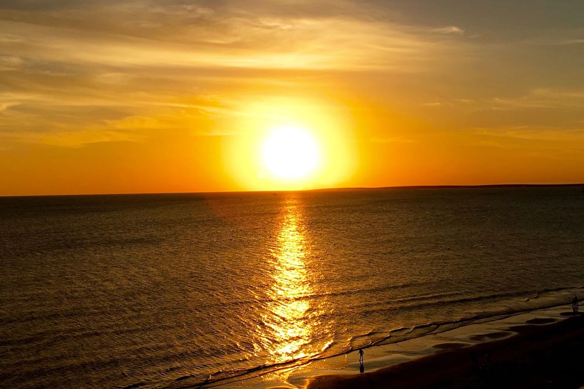 A sunset over a calm sea with a clear horizon.