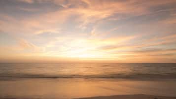 On the beach, white sand, beach cabanas, sun loungers