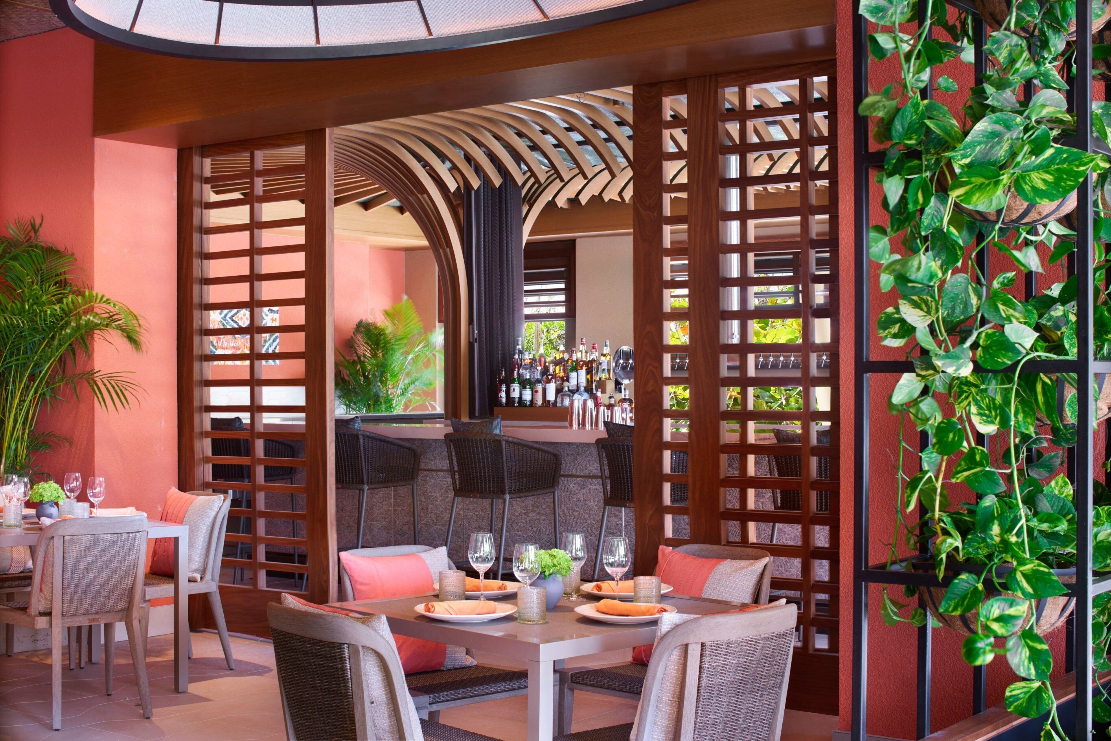 A restaurant with a bar area, outdoor seating, and a view of the street.