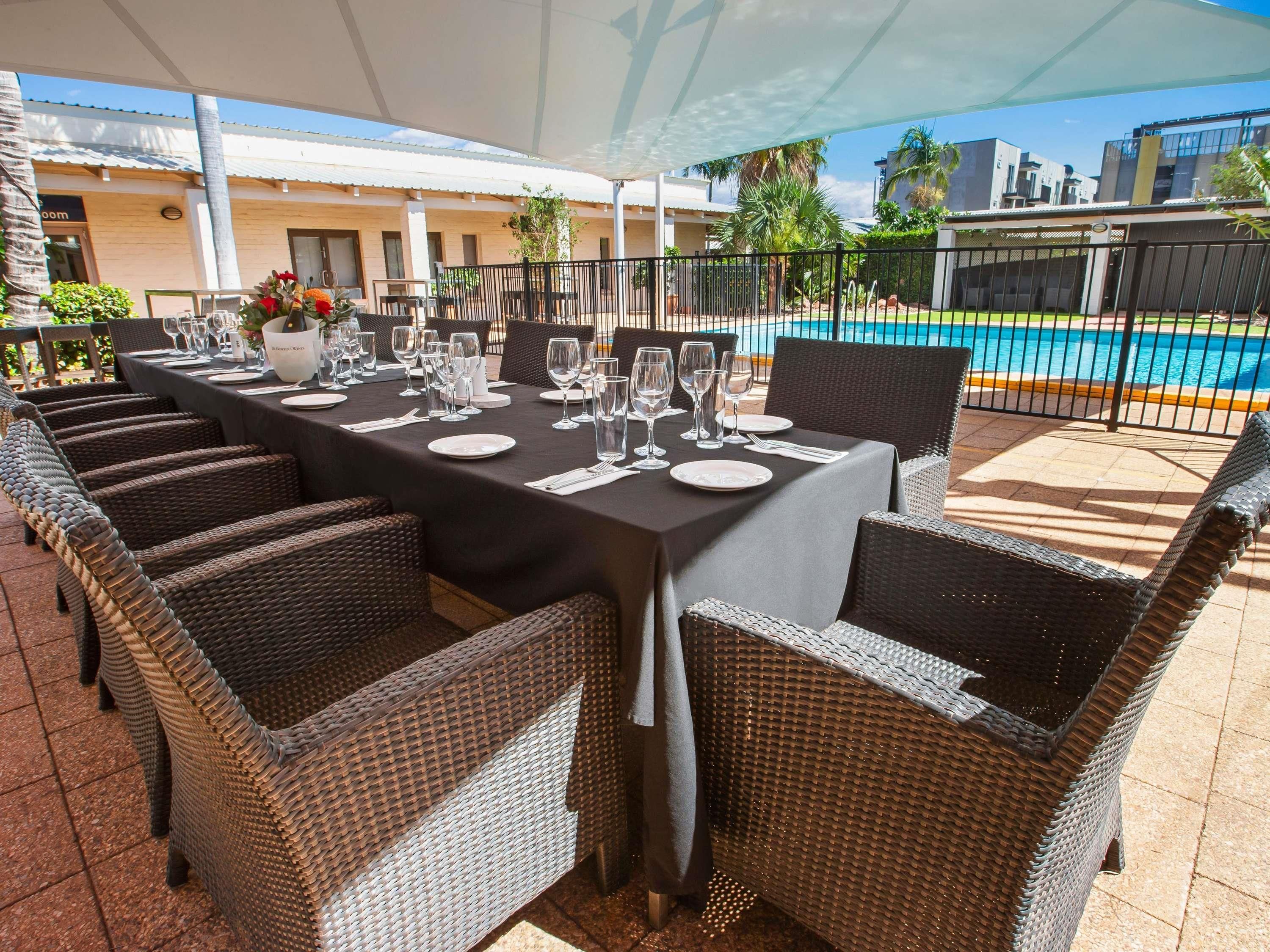 An outdoor dining area with wicker chairs and a table set for six.