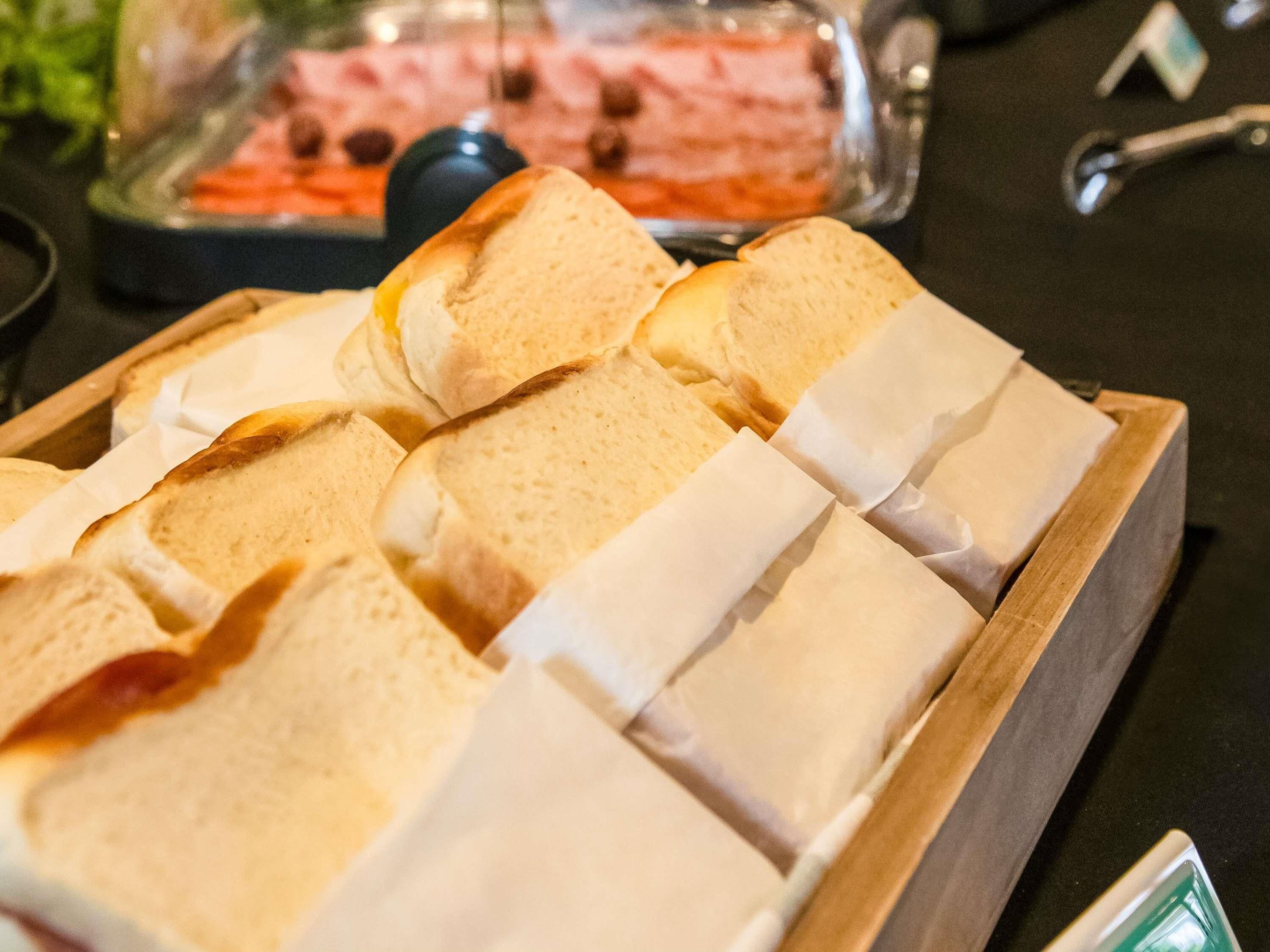 A tray of sliced bread on a wooden table.