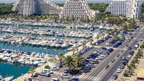 A marina with numerous boats docked, surrounded by modern buildings with unique architectural designs. - Mercure Grande Motte Port (La Grande-Motte)