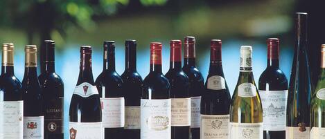 A row of wine bottles on a table with a blurred green background.