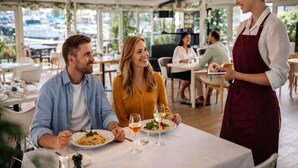 An indoor dining area with tables, chairs, and a waiter. - Mercure Grande Motte Port (La Grande-Motte)