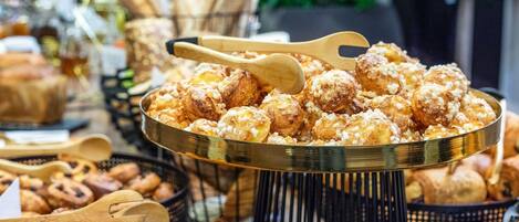A variety of baked goods including pastries and bread, arranged on a table with a metal tray.