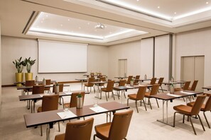 A conference room with tables and chairs, a projector screen, and a whiteboard. - Starhotels Tourist (Milan)