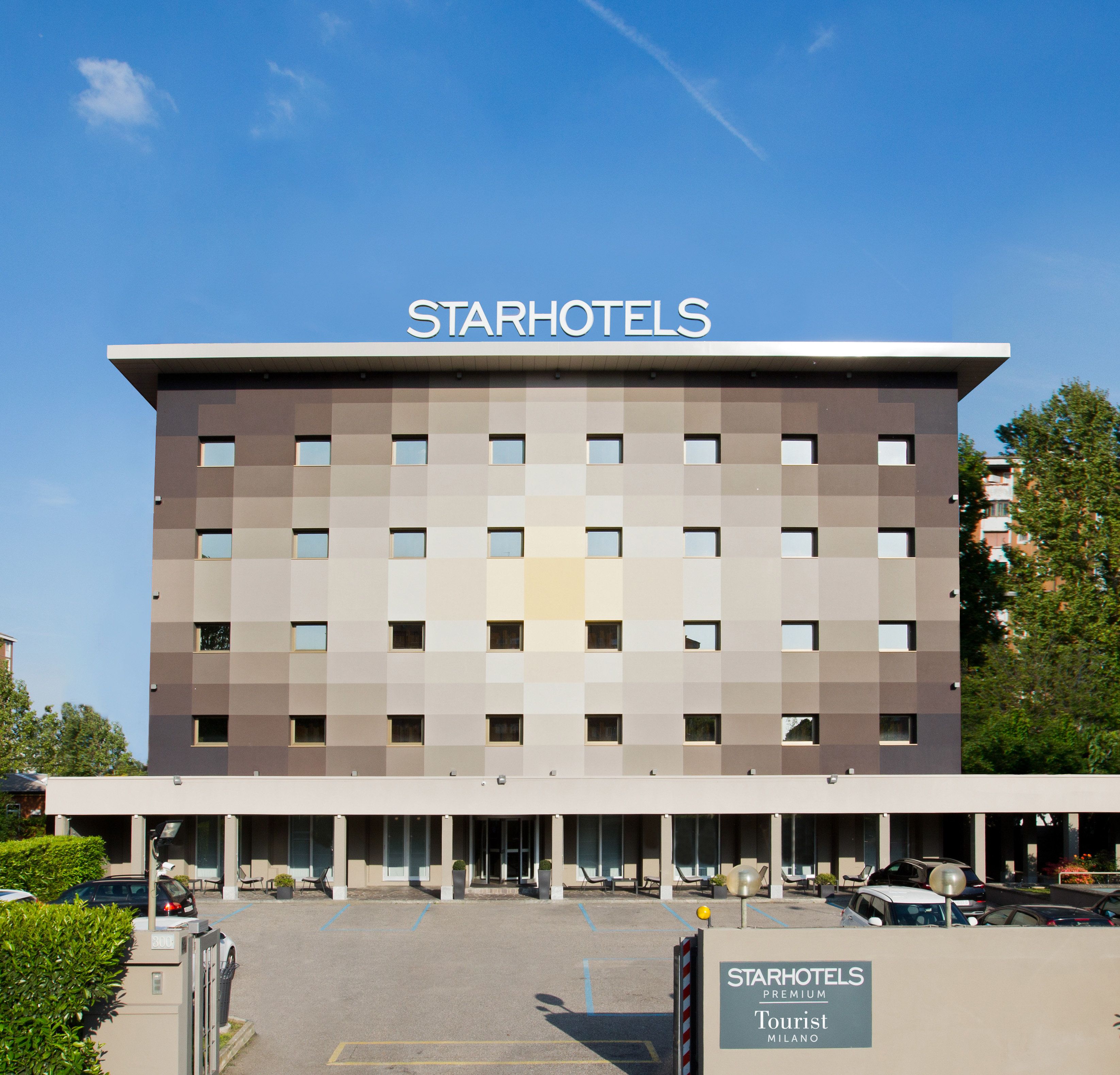 Un edificio de StarHotels de diseño moderno, con numerosas ventanas y un cielo despejado.